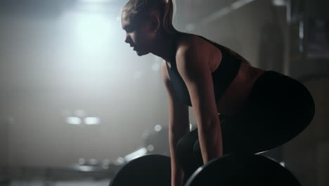 blonde-sporty-woman-is-working-hard-in-gym-lifting-barbell-slow-motion-in-training-fitness-hall